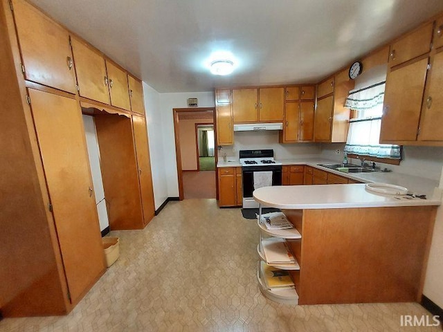 1800 N 350 W, Jasper, IN 47546 - kitchen featuring white range with gas stovetop, under cabinet range hood, a sink, a peninsula, and brown cabinets