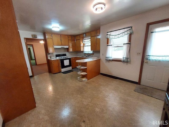 1800 N 350 W, Jasper, IN 47546 - kitchen featuring gas range oven, light countertops, under cabinet range hood, brown cabinets, and a sink