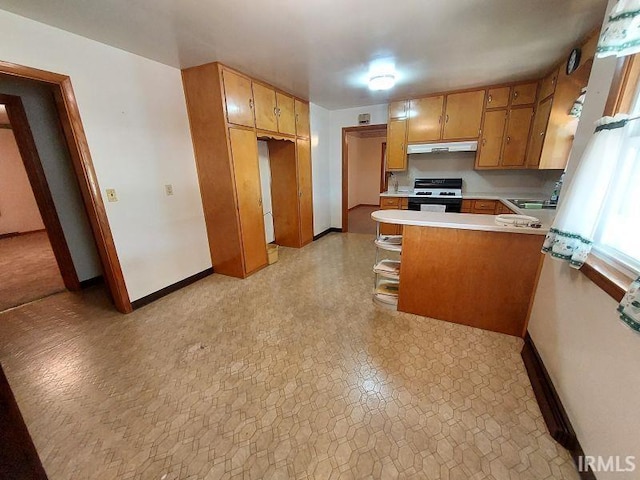 1800 N 350 W, Jasper, IN 47546 - kitchen with stove, under cabinet range hood, a peninsula, light countertops, and baseboards