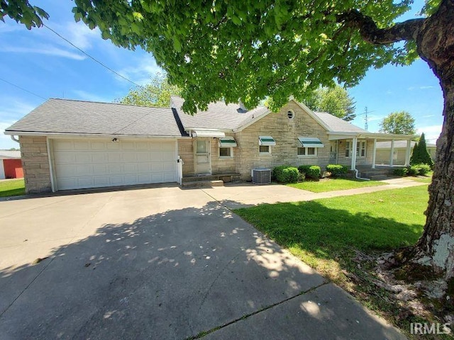 1800 N 350 W, Jasper, IN 47546 - view of front of house with stone siding, central AC unit, a front lawn, a garage, and driveway