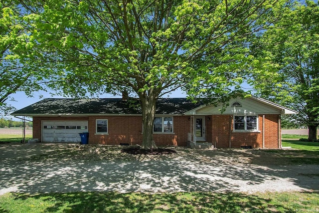 view of front of house with an attached garage, brick siding, and driveway