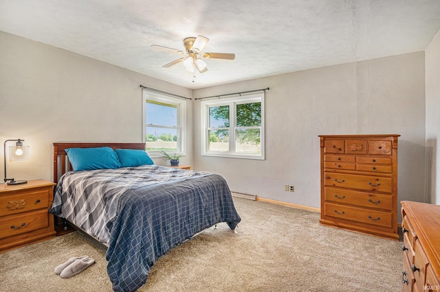 bedroom with light carpet, baseboards, ceiling fan, and a baseboard radiator