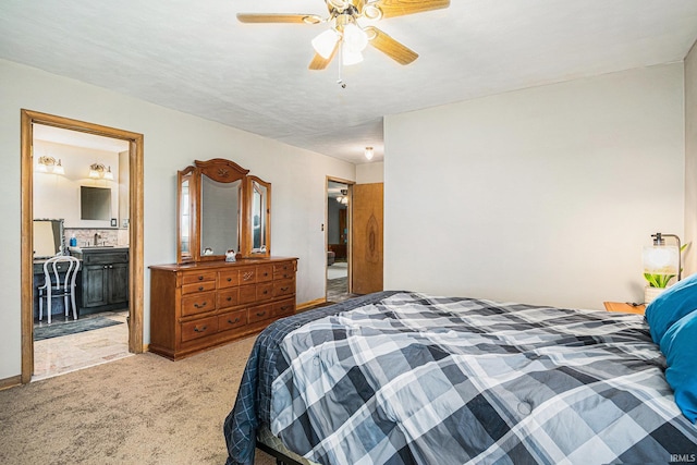 bedroom with light colored carpet, ceiling fan, and ensuite bath