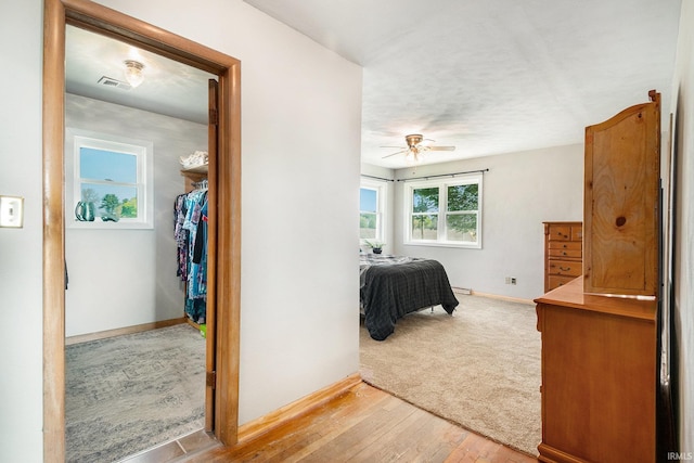 bedroom with baseboards, light wood-style flooring, and ceiling fan