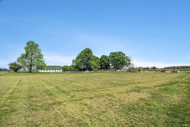 view of green lawn featuring a rural view