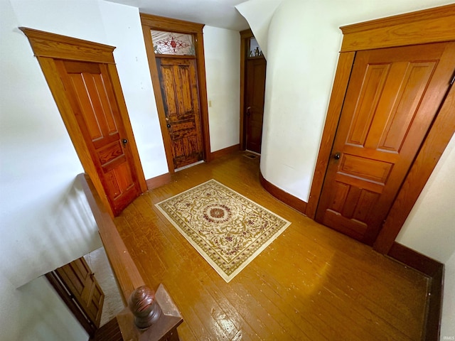 hall with wood-type flooring and baseboards