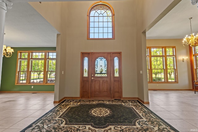 foyer with a chandelier, tile patterned flooring, plenty of natural light, and a high ceiling