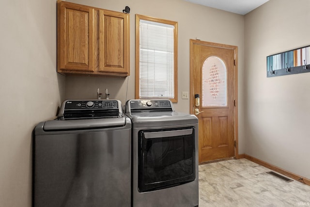 laundry room with cabinet space, independent washer and dryer, and baseboards