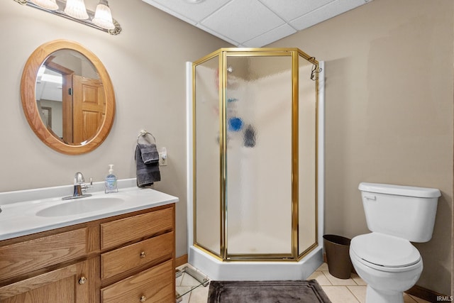 full bathroom with tile patterned flooring, a shower stall, toilet, vanity, and a paneled ceiling