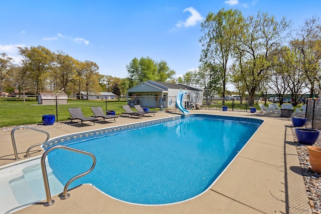 view of swimming pool featuring a water slide and a patio area