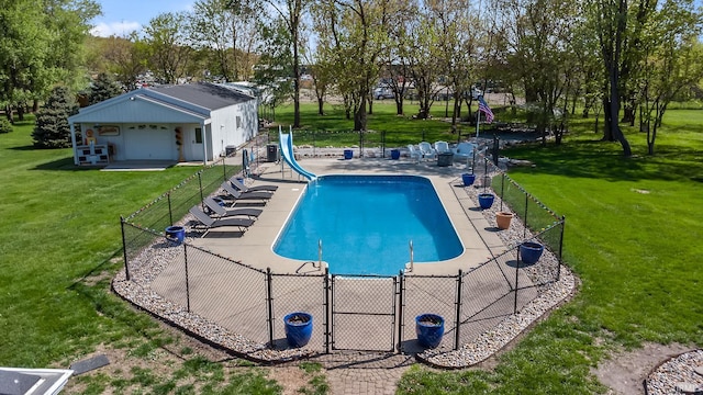 view of pool with a water slide, a gate, a patio area, and view of wooded area