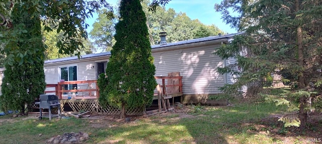back of house featuring a wooden deck and metal roof