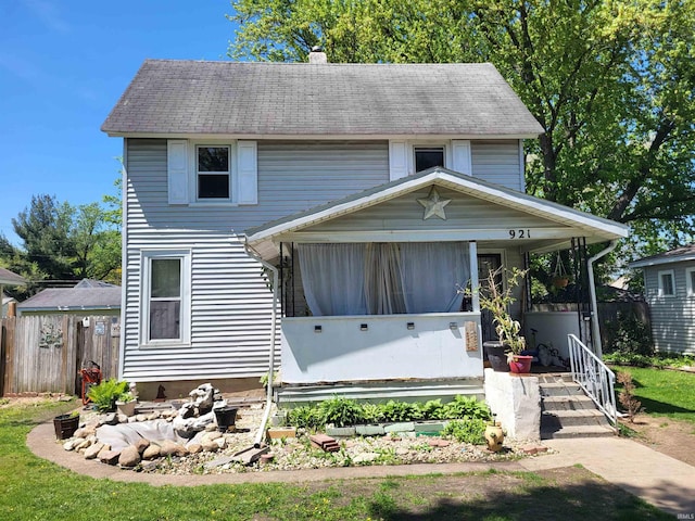 view of front of property with a chimney, fence, and a porch