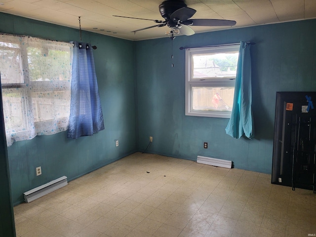 empty room with a baseboard radiator, ceiling fan, and tile patterned floors