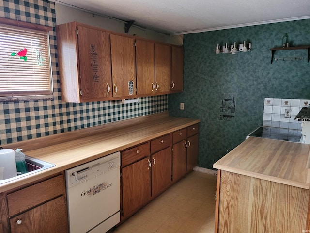 kitchen featuring white dishwasher, ornamental molding, light floors, a sink, and brown cabinetry