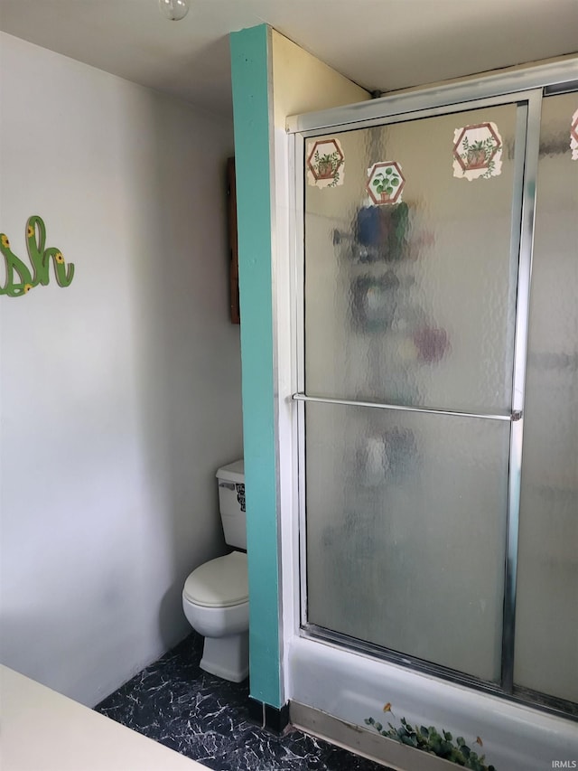 bathroom featuring marble look tile flooring, an enclosed shower, and toilet