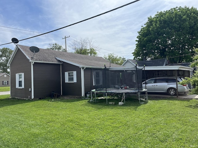502 W Vantrees St, Washington, IN 47501 - rear view of house featuring a trampoline, a yard, and roof with shingles