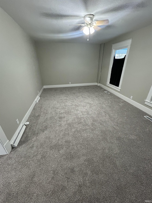 carpeted empty room featuring ceiling fan, baseboards, a baseboard radiator, and a textured ceiling