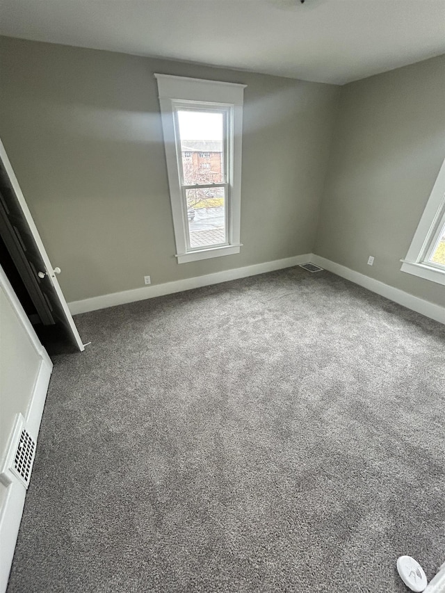 spare room with baseboards and carpet