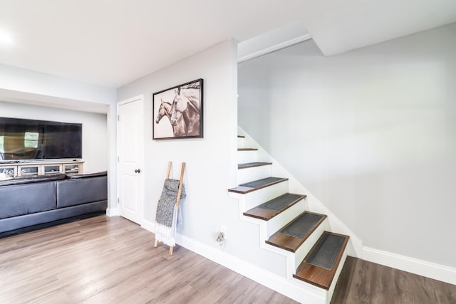 stairs with wood finished floors and baseboards