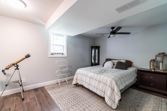 bedroom with wood finished floors, baseboards, and a ceiling fan