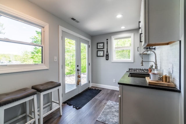 doorway to outside with a sink, plenty of natural light, dark wood-style flooring, baseboards, and recessed lighting