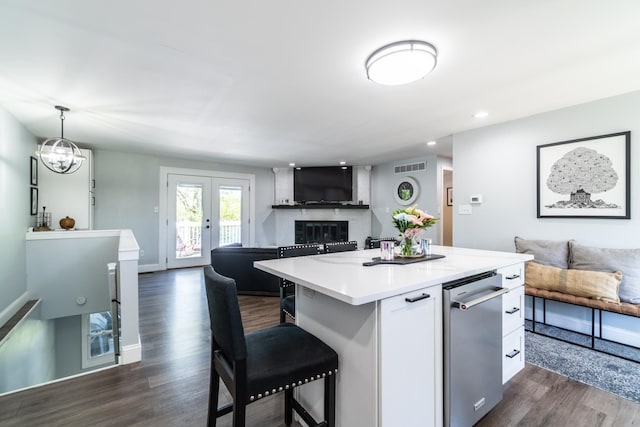 kitchen with open floor plan, dark wood-type flooring, a kitchen island, white cabinets, and recessed lighting