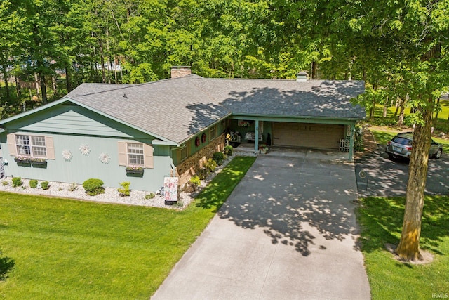 410 Longtree Ln, Logansport, IN 46947 - view of front of home with a garage, a chimney, a front lawn, and concrete driveway