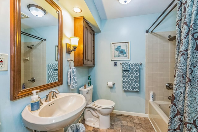 410 Longtree Ln, Logansport, IN 46947 - full bathroom featuring a sink, stone finish flooring, baseboards, shower / bath combo with shower curtain, and toilet