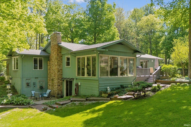 410 Longtree Ln, Logansport, IN 46947 - back of house featuring a chimney, a patio area, a sunroom, and a yard