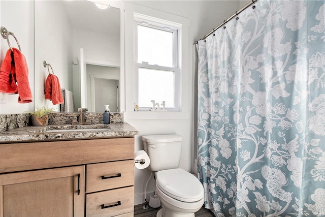 full bath with toilet, vanity, and wood finished floors