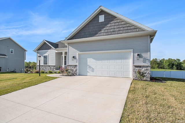 view of front of home with stone siding, an attached garage, and driveway
