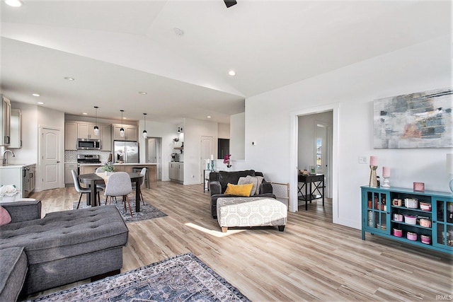 living room with light wood-style flooring, recessed lighting, and vaulted ceiling