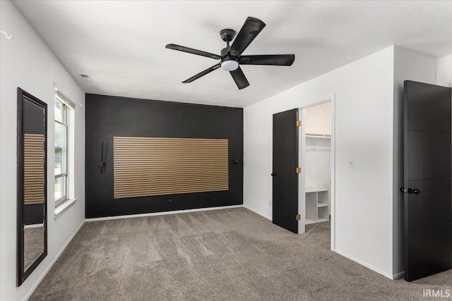 214 Mccutcheon Dr, Lafayette, IN 47909 - unfurnished bedroom with carpet floors, a textured ceiling, a spacious closet, a ceiling fan, and baseboards