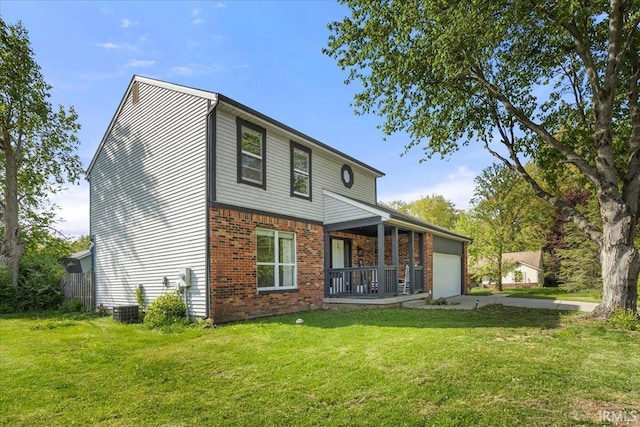 214 Mccutcheon Dr, Lafayette, IN 47909 - back of house with a garage, a lawn, brick siding, a porch, and concrete driveway