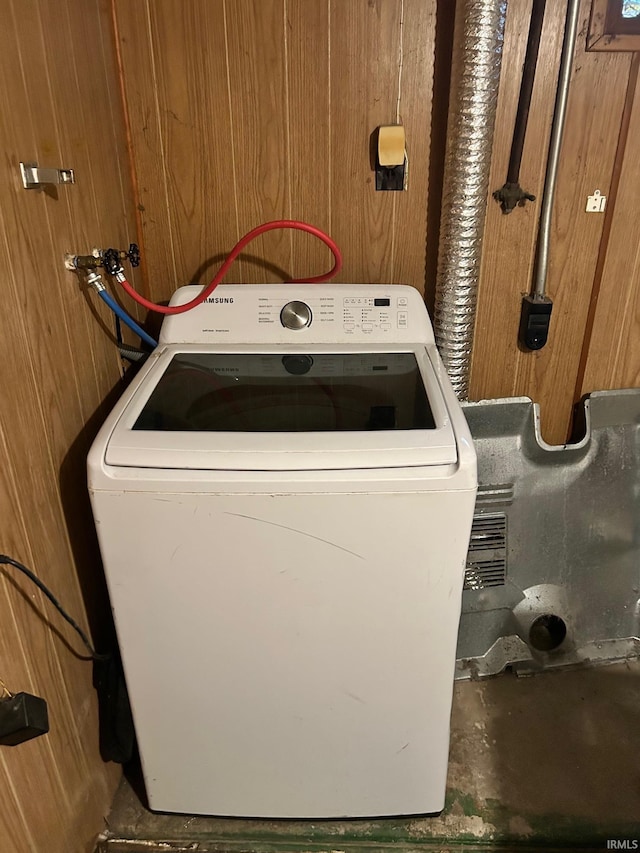 clothes washing area featuring washer / dryer and wood walls