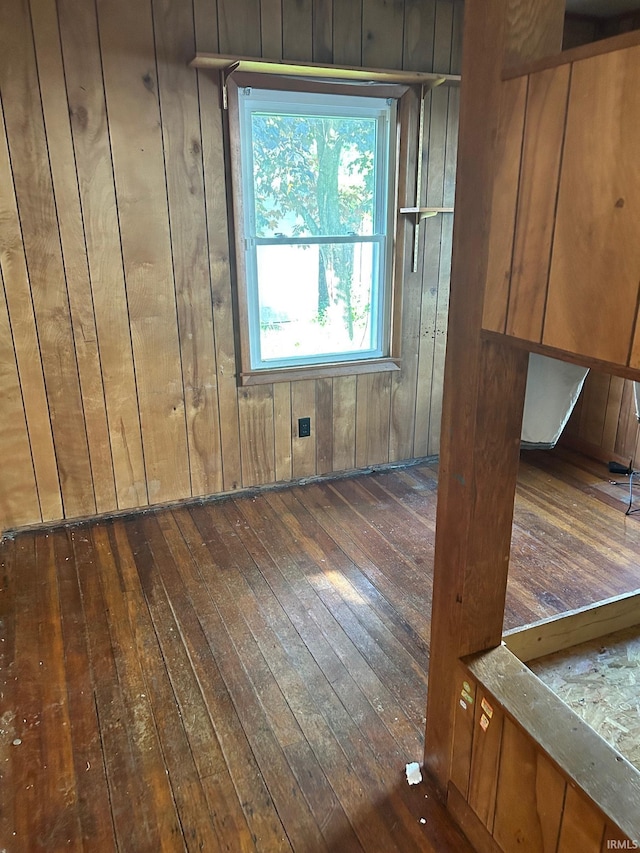 spare room featuring dark wood-type flooring and wood walls