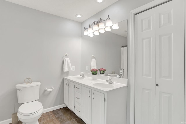 4113 S Hedgewood Ct, Bloomington, IN 47403 - bathroom featuring toilet, baseboards, a closet, double vanity, and recessed lighting
