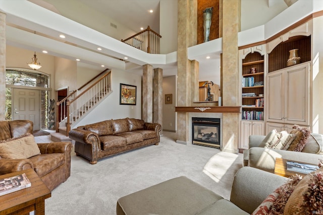 23306 Bluff Crest Dr, Elkhart, IN 46516 - carpeted living area with a towering ceiling, stairs, recessed lighting, a premium fireplace, and built in features
