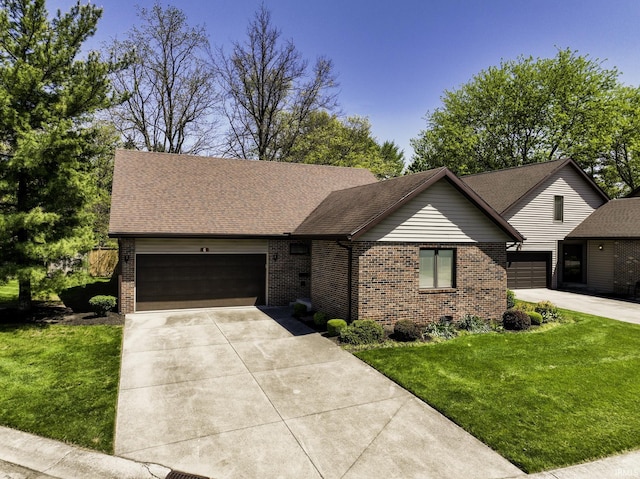 3400 W Riggin Rd Unit 6, Muncie, IN 47304 - view of front of house featuring brick siding, concrete driveway, an attached garage, a front lawn, and a shingled roof