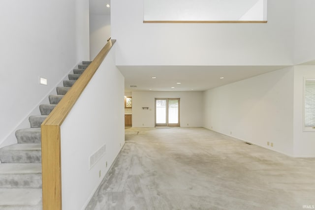 3400 W Riggin Rd Unit 6, Muncie, IN 47304 - unfurnished living room with carpet floors, stairs, a towering ceiling, and recessed lighting