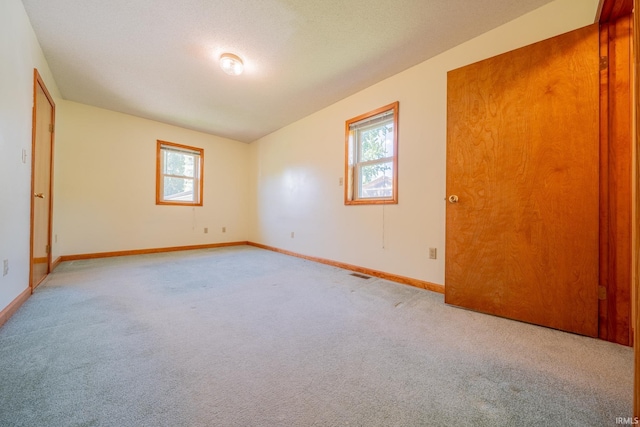 109 E Grant St, Lafontaine, IN 46940 - unfurnished bedroom featuring multiple windows, light colored carpet, and baseboards
