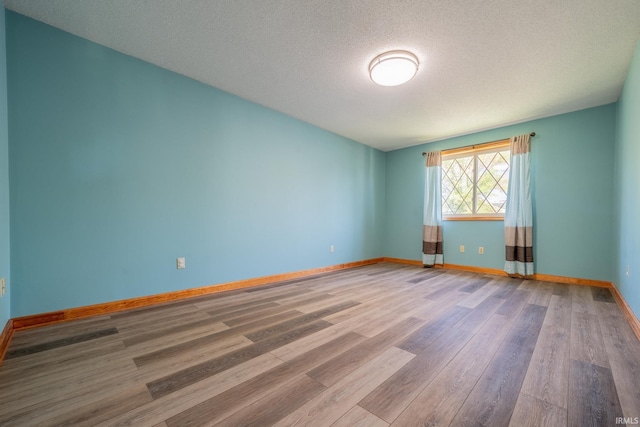 109 E Grant St, Lafontaine, IN 46940 - spare room with wood finished floors, baseboards, and a textured ceiling