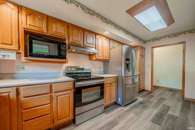 109 E Grant St, Lafontaine, IN 46940 - kitchen featuring appliances with stainless steel finishes, under cabinet range hood, light wood finished floors, and light countertops