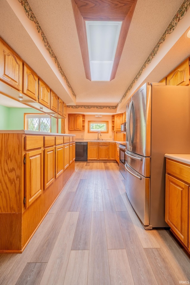 109 E Grant St, Lafontaine, IN 46940 - kitchen with stainless steel appliances, light wood-style floors, light countertops, a sink, and brown cabinetry