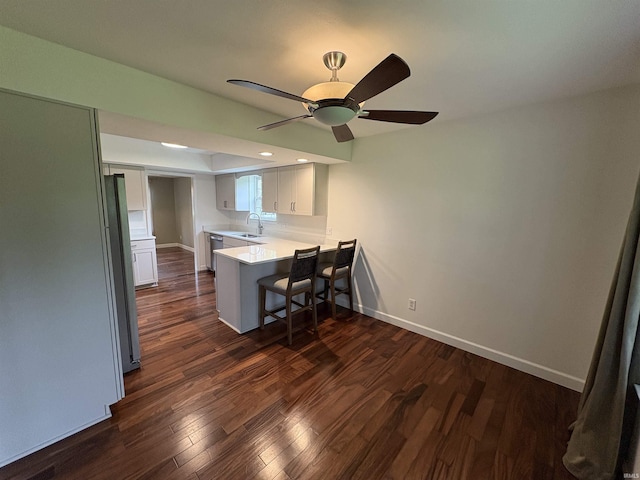 1643 W 1st St, Jasper, IN 47546 - kitchen featuring a peninsula, a sink, a breakfast bar area, white cabinetry, and a ceiling fan