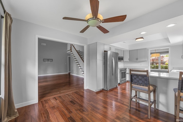1643 W 1st St, Jasper, IN 47546 - kitchen with stainless steel appliances, a breakfast bar area, dark wood-style floors, ceiling fan, and light countertops