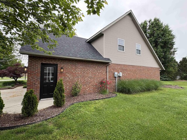 1643 W 1st St, Jasper, IN 47546 - view of side of property with brick siding, a yard, and roof with shingles
