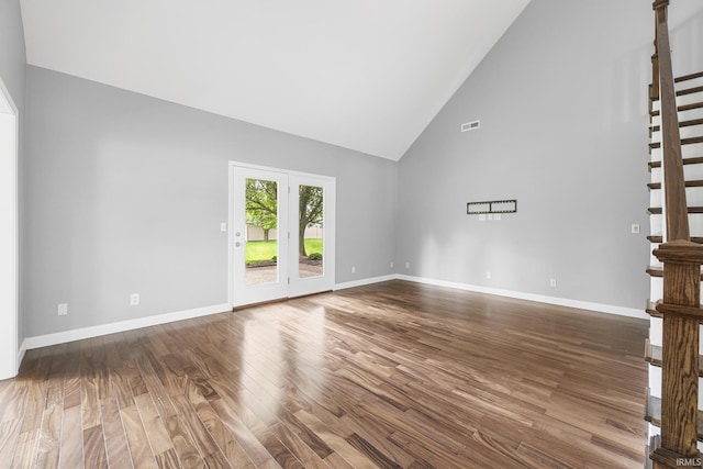 1643 W 1st St, Jasper, IN 47546 - unfurnished living room with high vaulted ceiling, dark wood finished floors, stairs, and baseboards