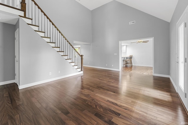 1643 W 1st St, Jasper, IN 47546 - unfurnished living room with high vaulted ceiling, stairs, wood finished floors, ceiling fan, and baseboards